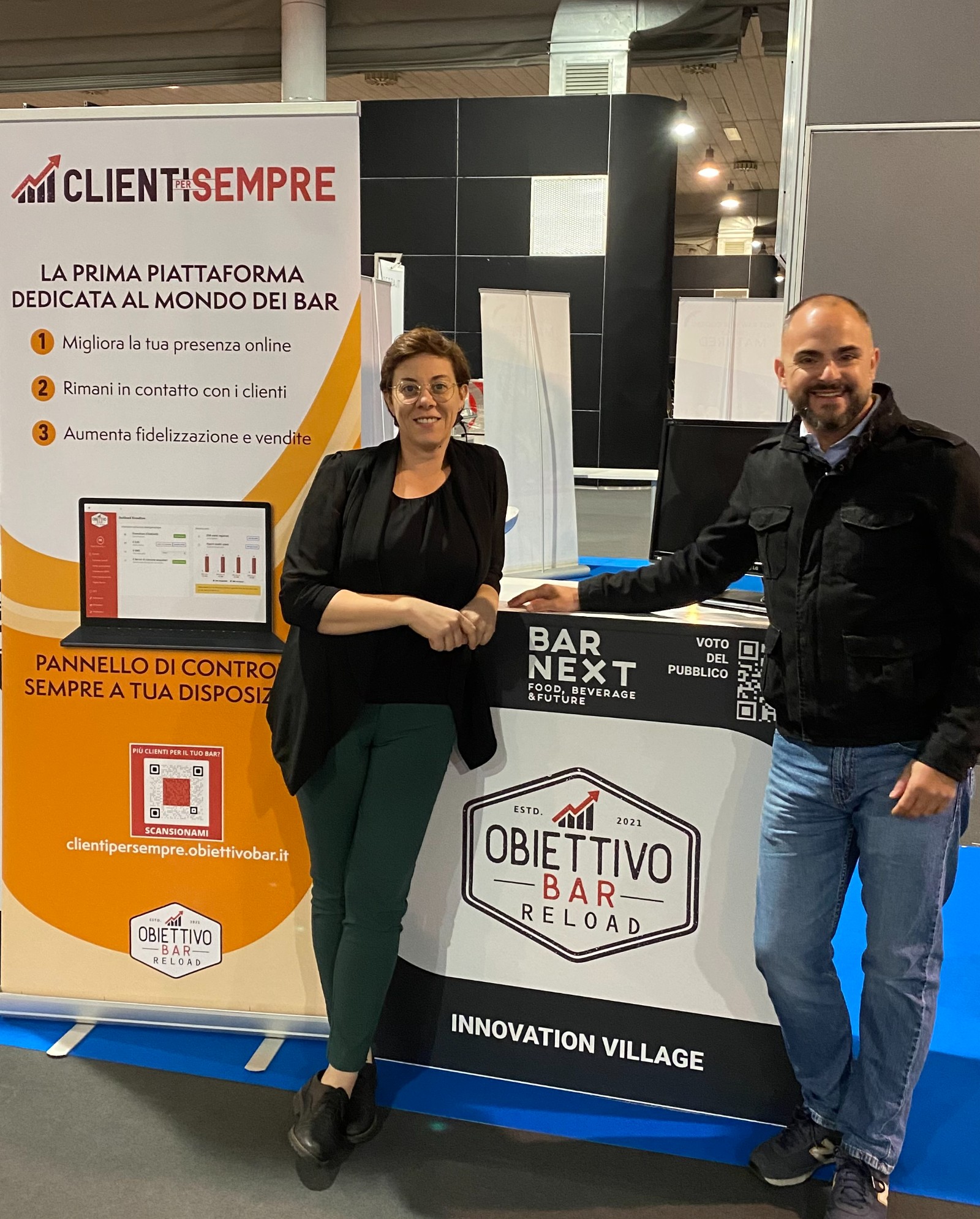 Chiara Valenti e Francesco Boccardo allo stand di Obiettivo Bar, davanti al banner col marchio